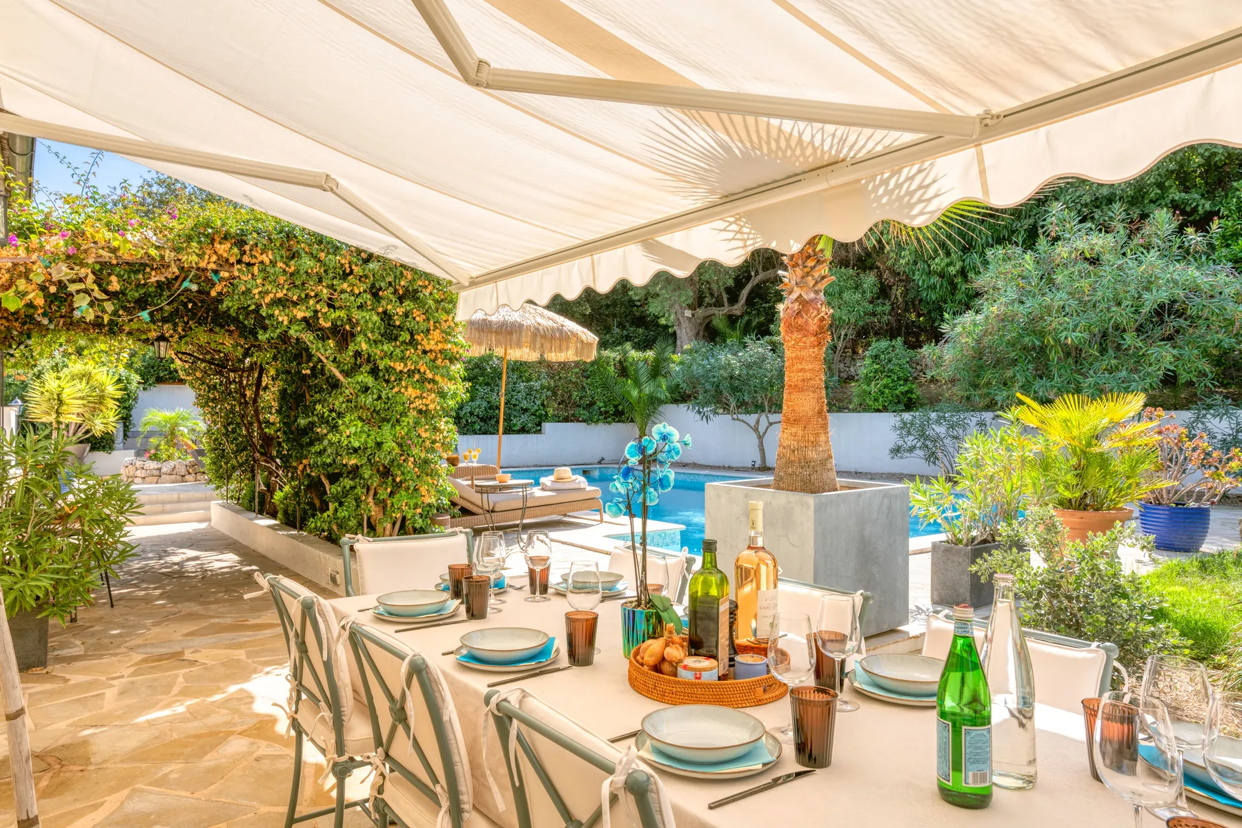 A shaded outdoor table laid for lunch beside the garden
